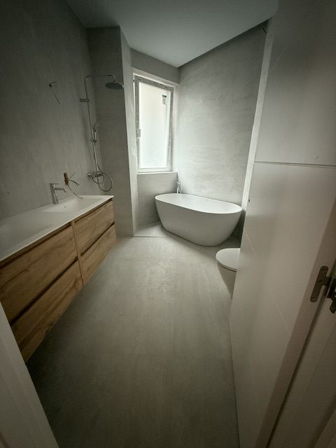 Baño con bañera exenta y mueble de madera