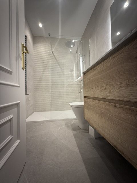 Pasillo con molduras y mueble de madera a medida